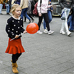 Street photography: a red balloon, a fabric stall and the girl in yellow
