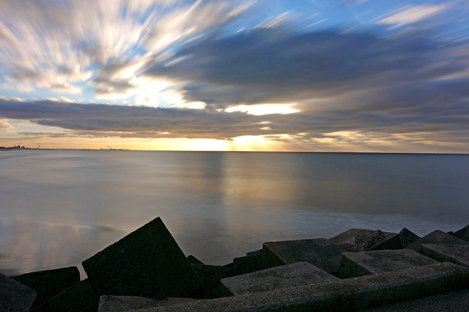 Both the waves and the clouds have been heavily 'smoothed out' by the long shutter speed of 60 sec at ISO 100 and f/6.3.